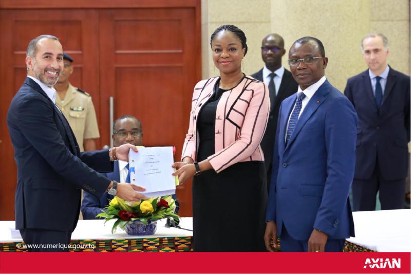 Signature de l'acquisition de 51 % de l'opérateur Togocom par le consortium Agou Holding, représenté par Hassanein Hiridjee, P-dg du conglomérat malgache Axian (à gauche). - © Axian/État togolais Signature de l'acquisition de 51 % de l'opérateur Togocom par le consortium Agou Holding, représenté par Hassanein Hiridjee, P-dg du conglomérat malgache Axian (à gauche). - © Axian/État togolais